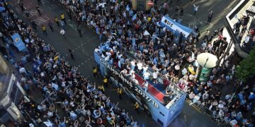 Manchester City celebrate Premier League title win with bus parade and manager Pep Guardiola throws a beer to fans