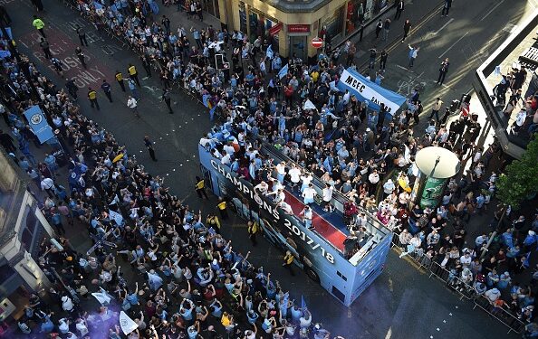 Manchester City celebrate Premier League title win with bus parade and manager Pep Guardiola throws a beer to fans